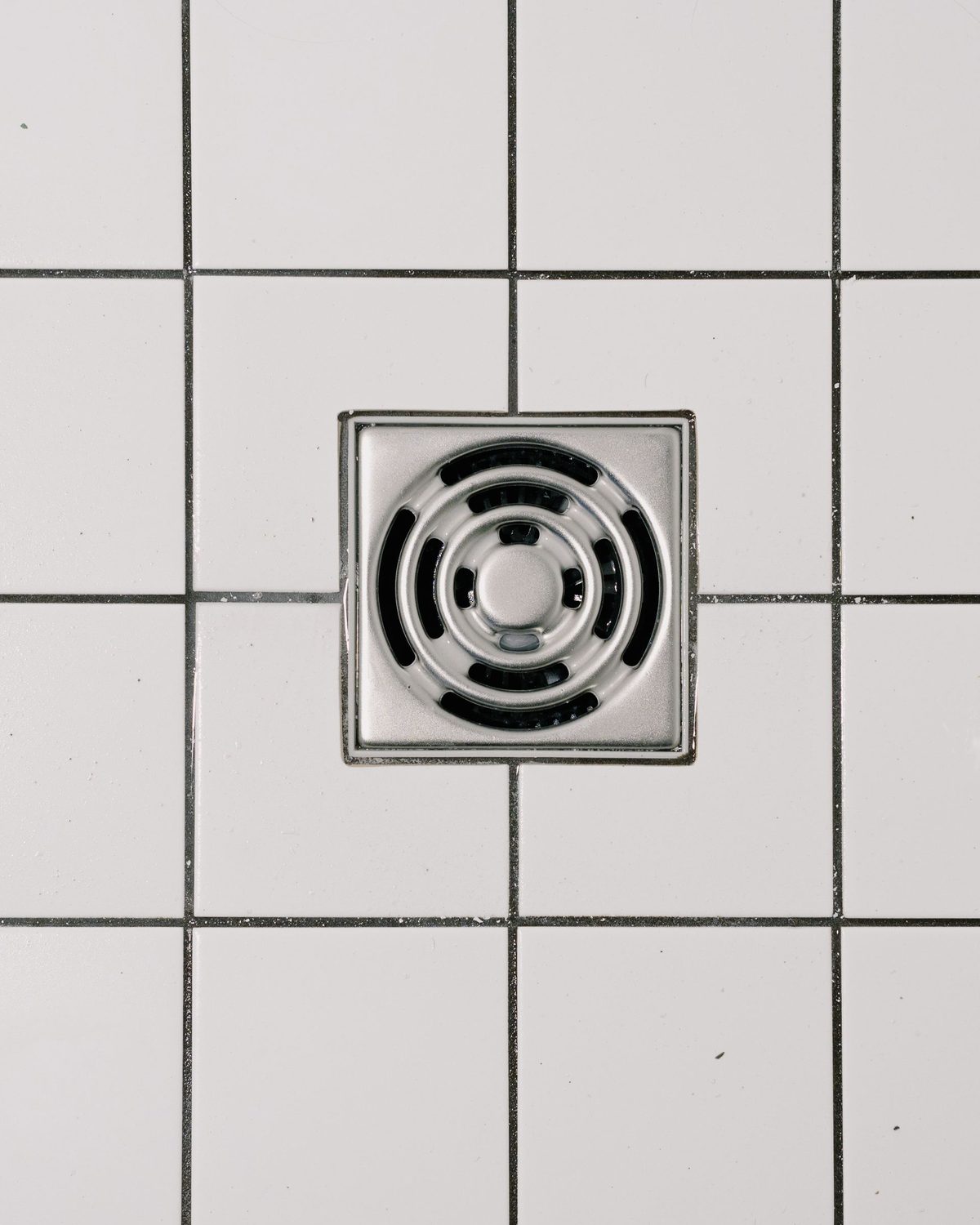 Stainless steel shower drain set in a tiled floor